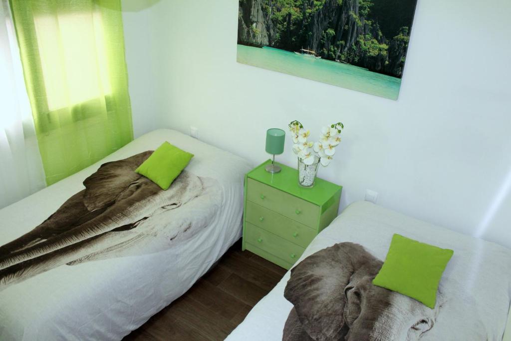 a bedroom with two beds and a vase of flowers at Natura Fira Barcelona in Hospitalet de Llobregat