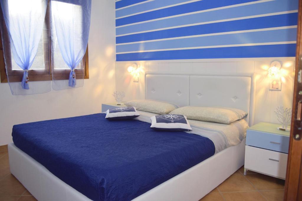 Un dormitorio con una cama azul y blanca con toallas. en IL MARE DI OLBIA Holiday Apartment en Olbia
