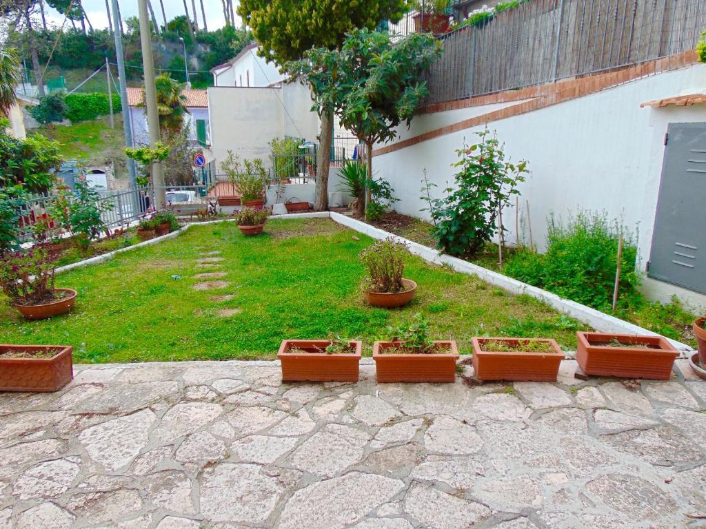 a garden with a bunch of potted plants on the ground at N209 - Numana, bilocale con giardino a 100 metri dal mare in Numana