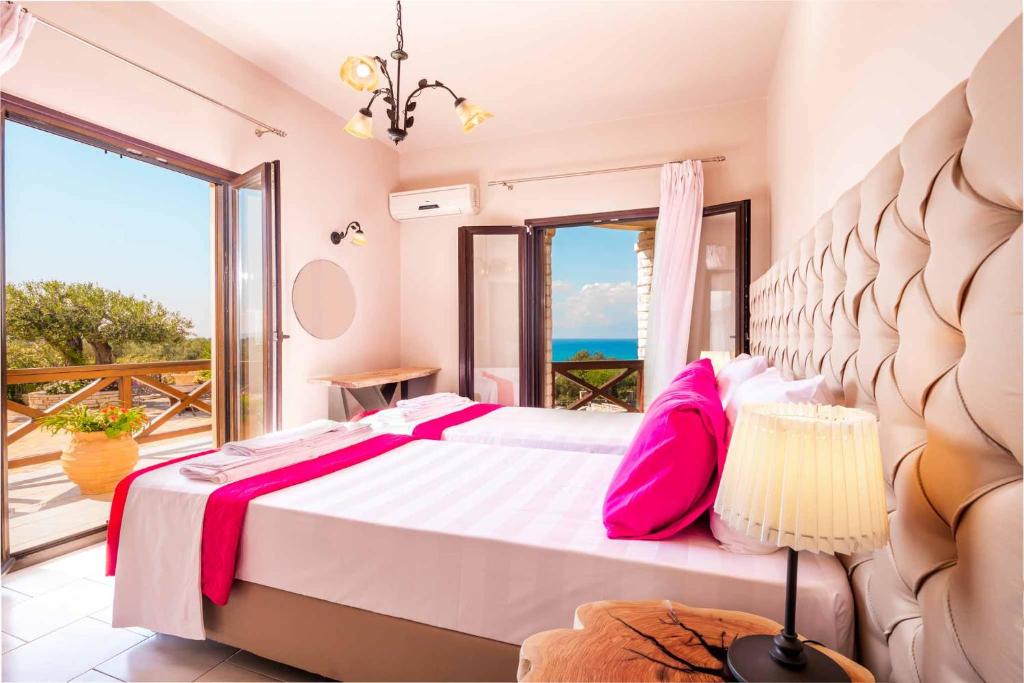 sypialnia z łóżkiem i widokiem na ocean w obiekcie Villa Irida Apartments Agios Spyridonas Peritheia w mieście Agios Spirydon