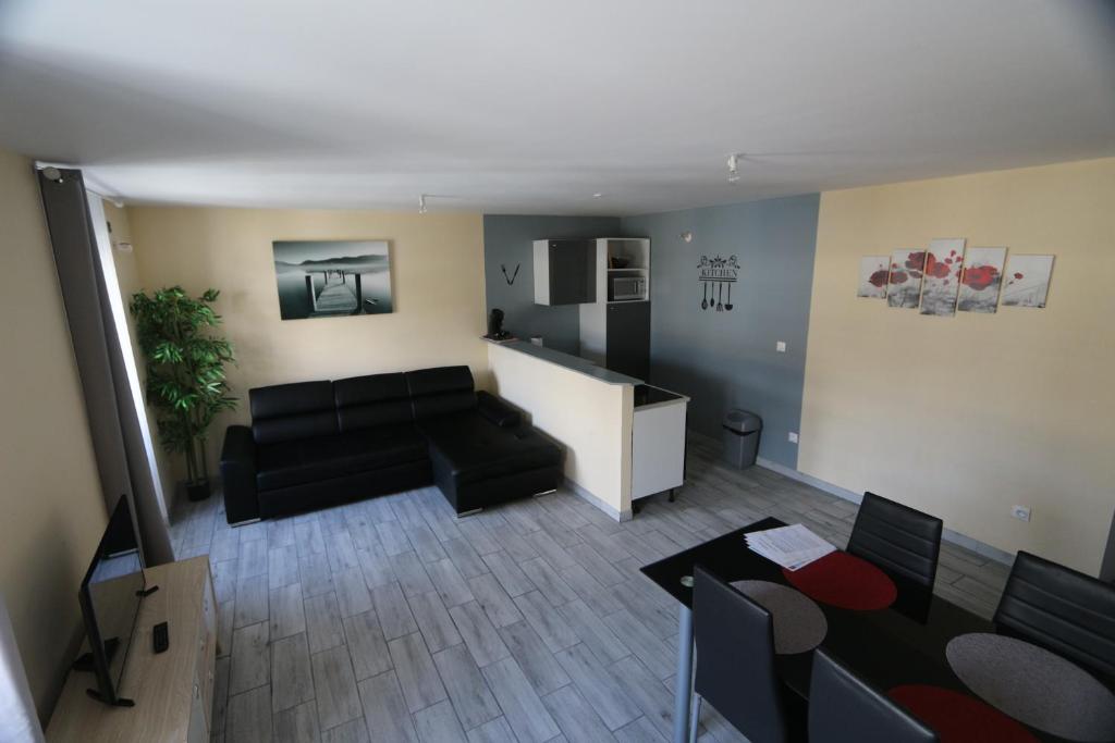 a living room with a black couch and a table at Apparts Gites Cholet centre in Cholet