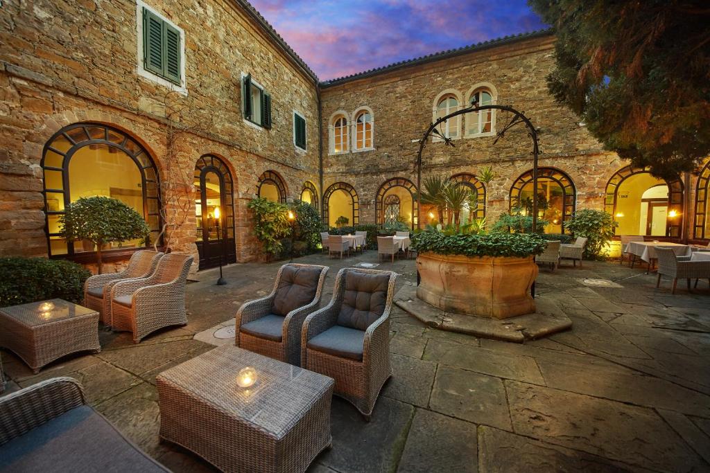 a courtyard with chairs and tables in a building at Villas - Hotel & Resort Adria Ankaran in Ankaran