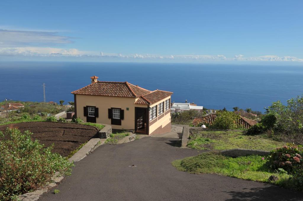 una casa en una colina con el océano en el fondo en Casa Rural Claudio, en Mazo