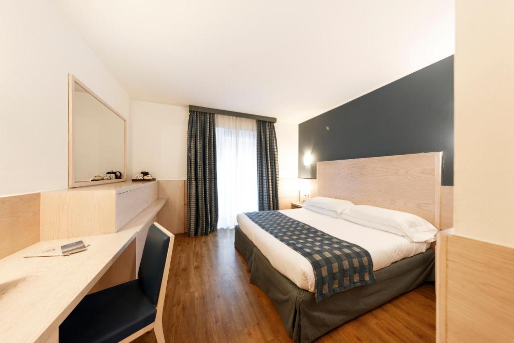 A bed or beds in a room at Caravel Bike Hotel