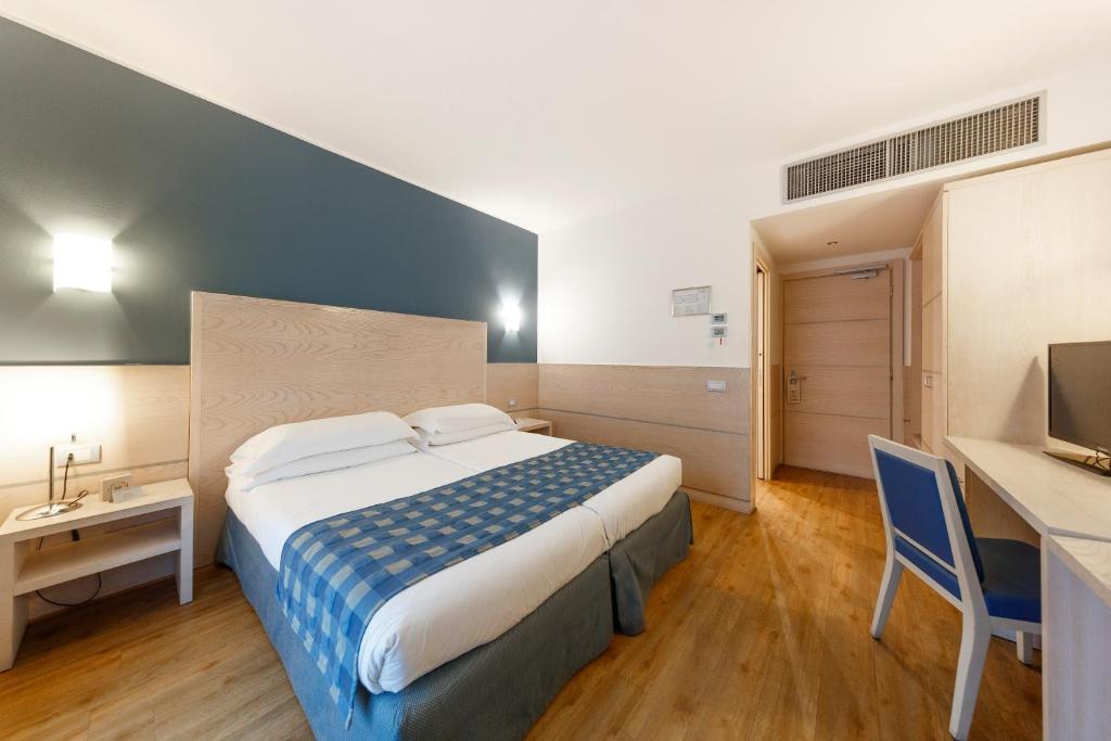 A bed or beds in a room at Caravel Bike Hotel