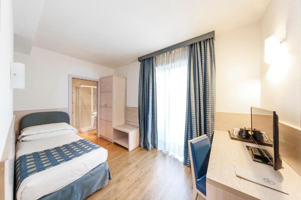 A bed or beds in a room at Caravel Bike Hotel