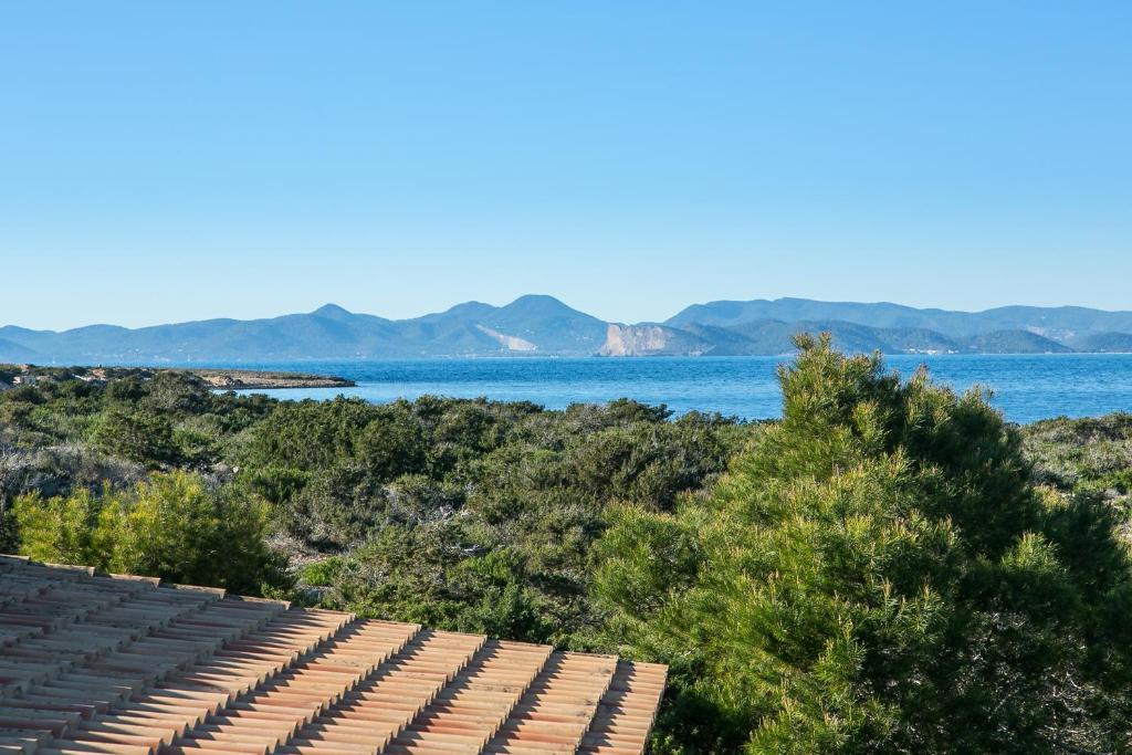 a view of the ocean from a building with chairs at Sa Voliaina in La Savina