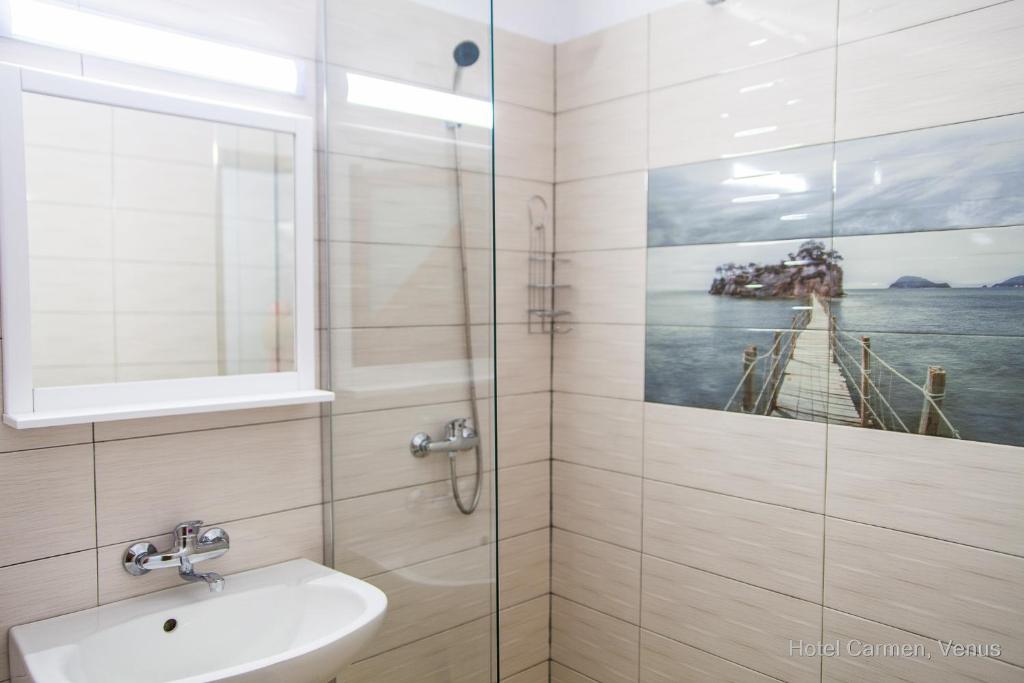 ein Bad mit einer Dusche mit einem Waschbecken und einem Bild eines Piers in der Unterkunft Hotel Carmen in Venus
