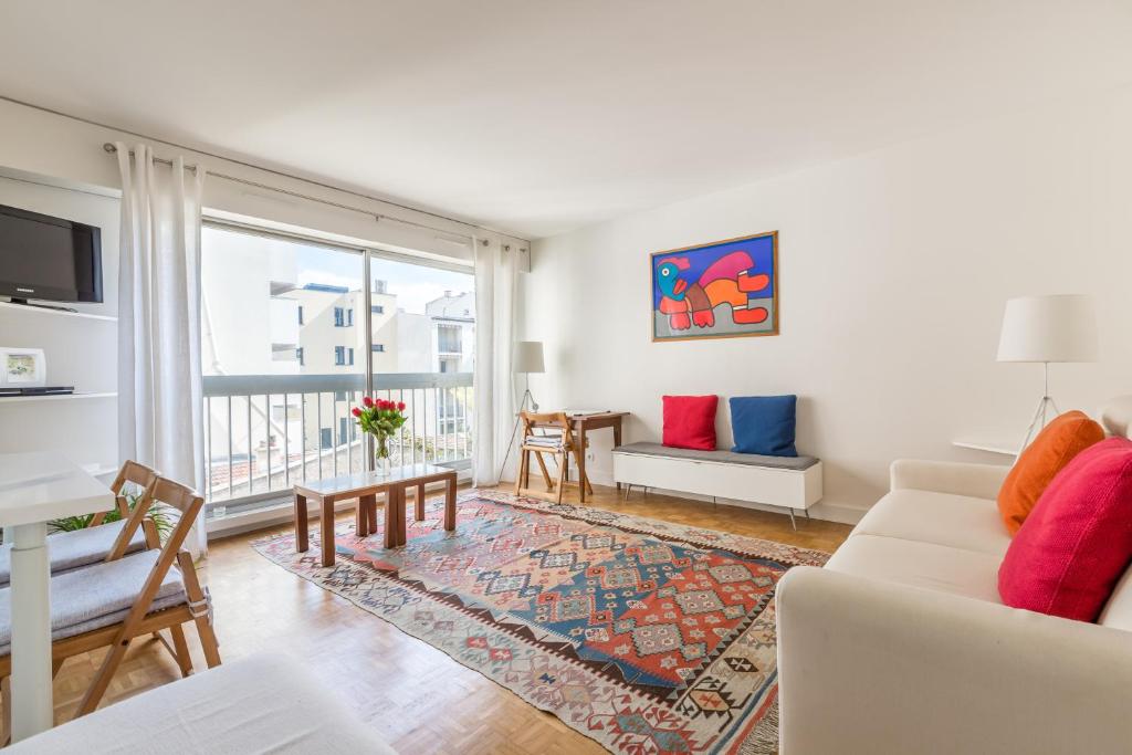 un salon avec un canapé et une table dans l'établissement Veeve - A Pop of Colour, à Paris