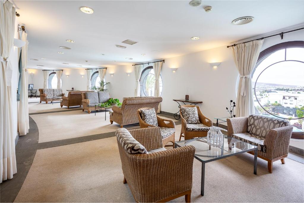 a large living room with chairs and a table at Hotel LIVVO Volcán Lanzarote in Playa Blanca
