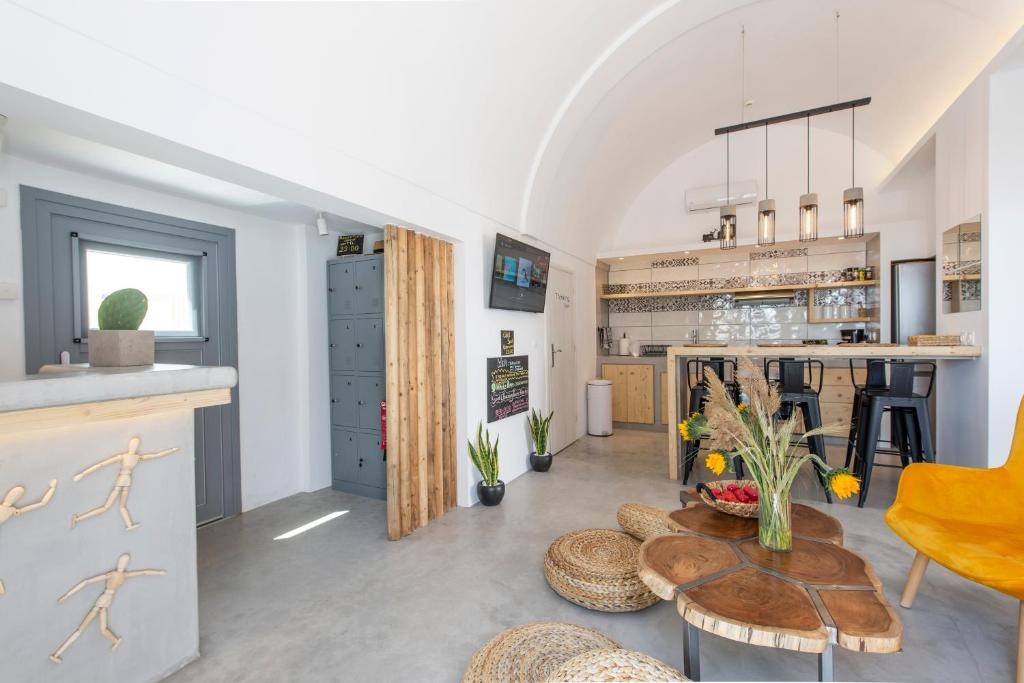a living room filled with furniture and a kitchen at Bedspot Hostel in Fira