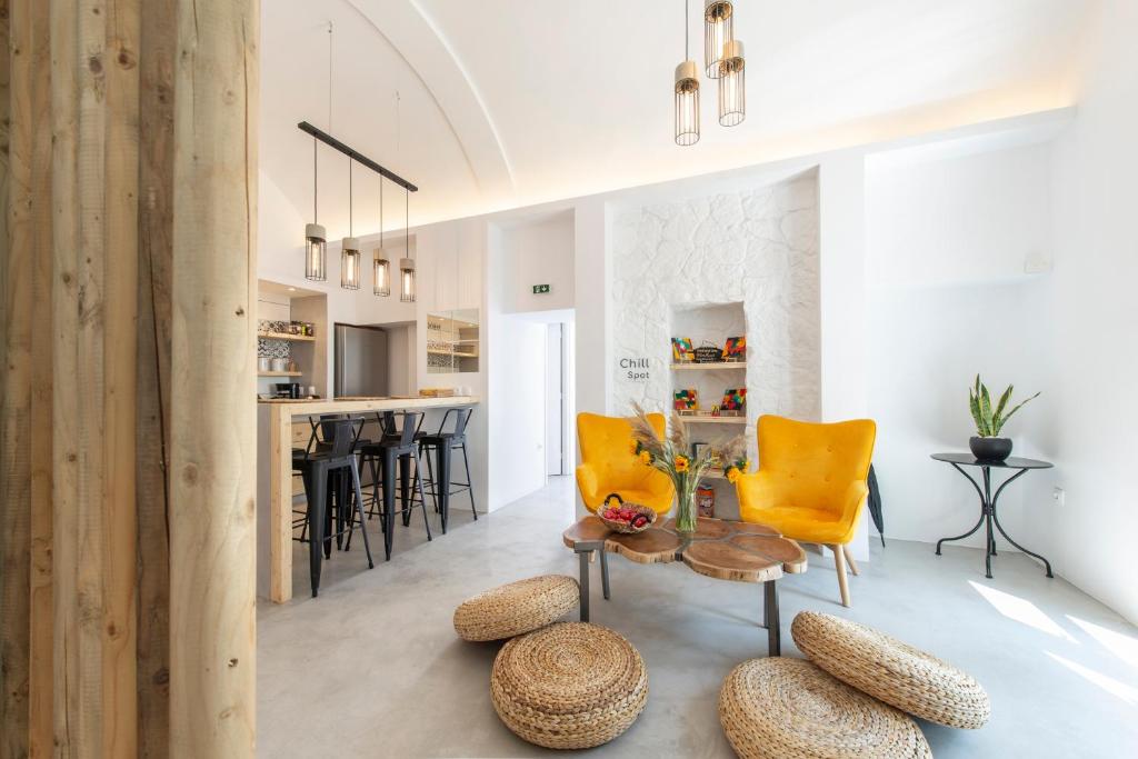 un soggiorno con tavolo e sedie gialle di Bedspot Hostel a Firà