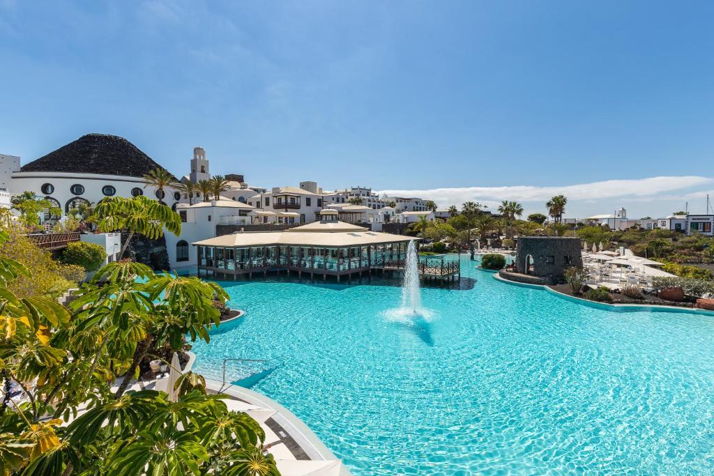 a pool at a resort with a fountain at Hotel LIVVO Volcán Lanzarote in Playa Blanca