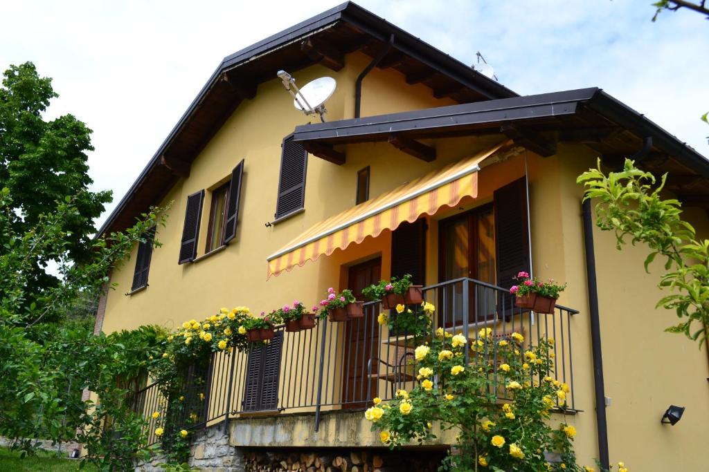 a yellow house with flowers on a balcony at Agriturismo Mandrola in Rivergaro