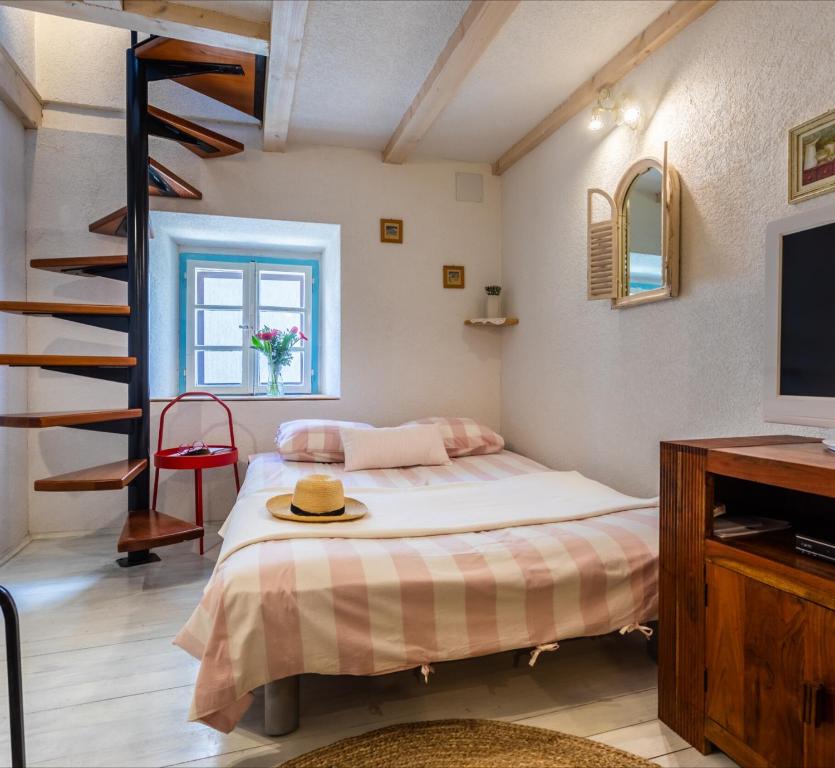 sypialnia z łóżkiem z kapeluszem w obiekcie Apartman Valdi w Bašce