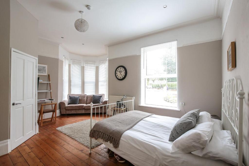 a bedroom with a bed and a couch and a clock at Baytree Lodge Chester in Chester