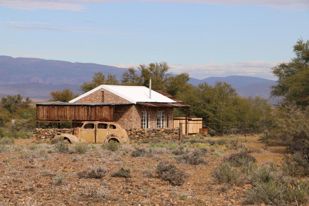 an old truck parked in front of a house at Wolvekraal Guest Farm in Prince Albert