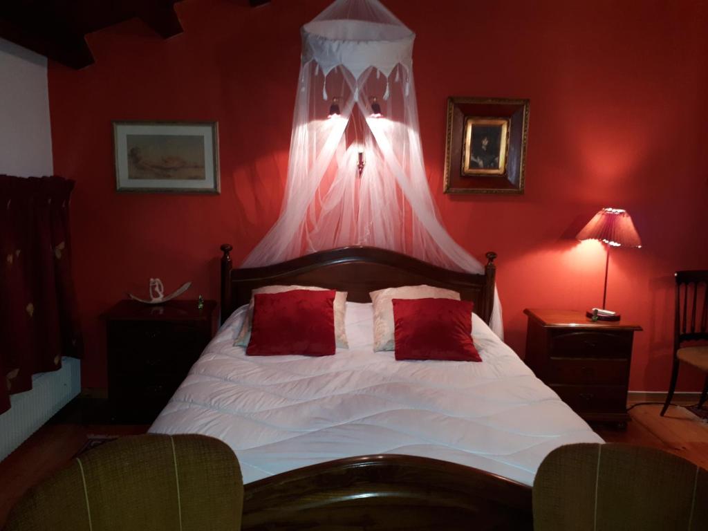 een rode slaapkamer met een bed met rode muren bij B&B Da Time in Vittorio Veneto