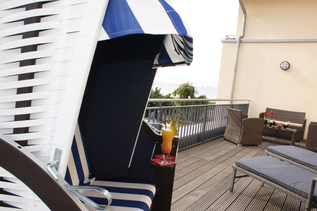 einen Balkon mit einem Sonnenschirm und einem Getränk auf dem Tisch in der Unterkunft Ferienwohnung Störtebekersuite in Glowe