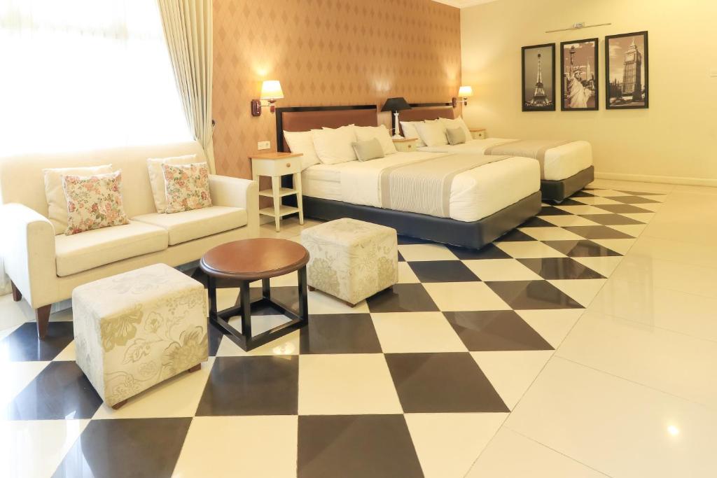 um quarto de hotel com uma cama e um piso de xadrez em HOME Guesthouse em Surabaya