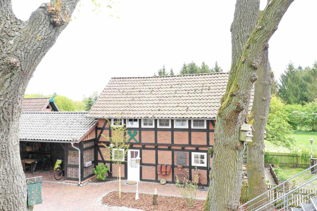 una grande casa con un albero di fronte di Haus Eichenhain a Scheessel
