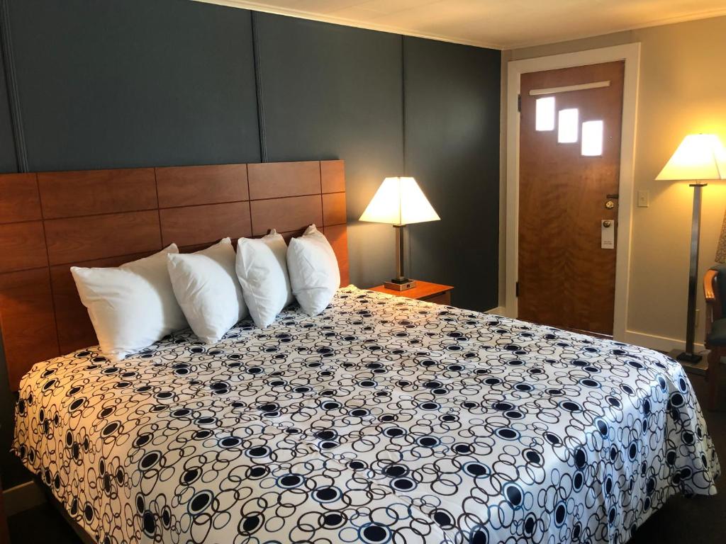 Habitación de hotel con cama con almohadas blancas en Edenbrook Motel, en Bar Harbor