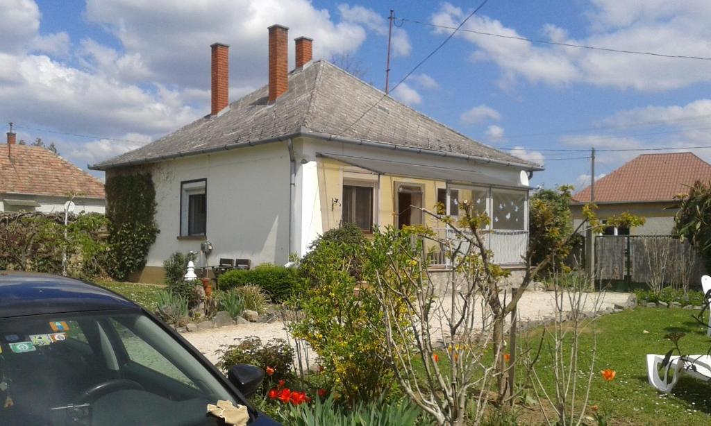 Bochmann Cottage في Zalaszántó: بيت ابيض فيه سياره متوقفه امامه