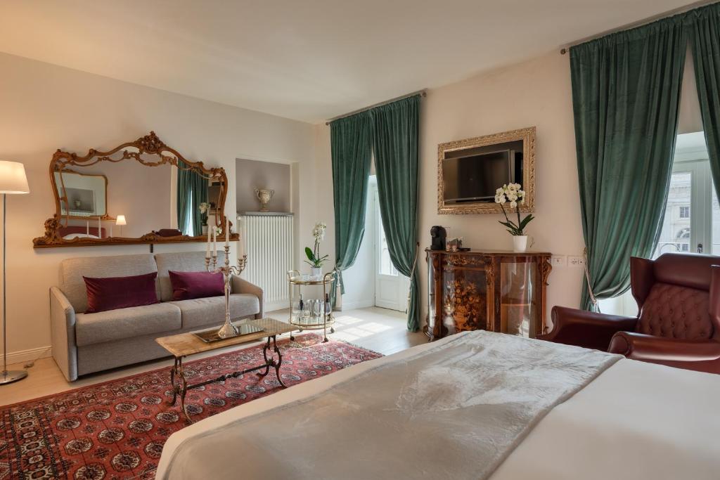 a bedroom with a bed and a couch and a mirror at Corte Realdi Luxury Rooms Torino in Turin