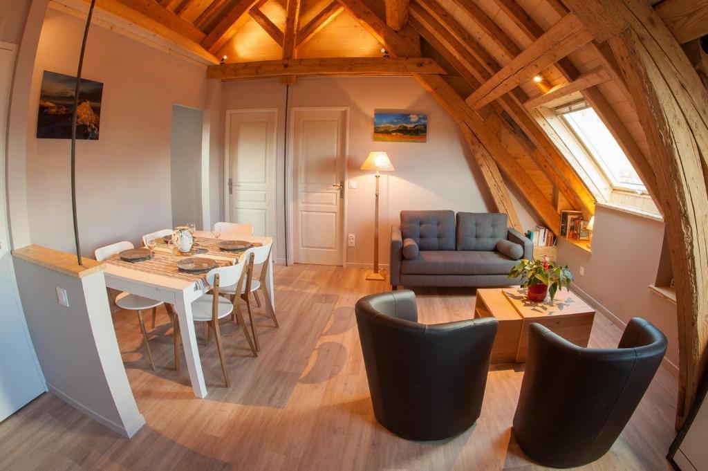 a dining room and living room with a table and chairs at Gite de la Petite Ecole in Lans-en-Vercors