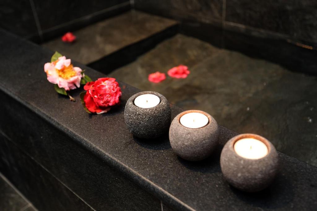 a group of candles and flowers on a table at Yunoyado Onsen Hot Spring Hotel -Xinyi Branch in Jiaoxi