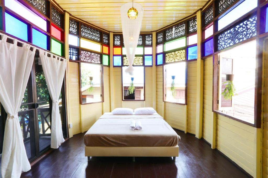 a bedroom with a bed in a room with windows at Baankhon Private room in Thai house Adult only Check in by yourself in Bangkok