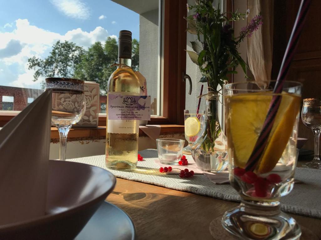 una botella de vino sentada en una mesa con una copa en Rustical Apartment in Sumava National Park en Nová Pec