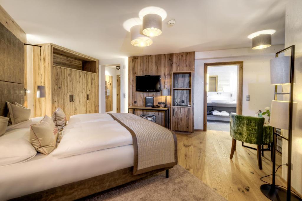 a hotel room with a large bed and a television at Hotel Brigitte in Ischgl