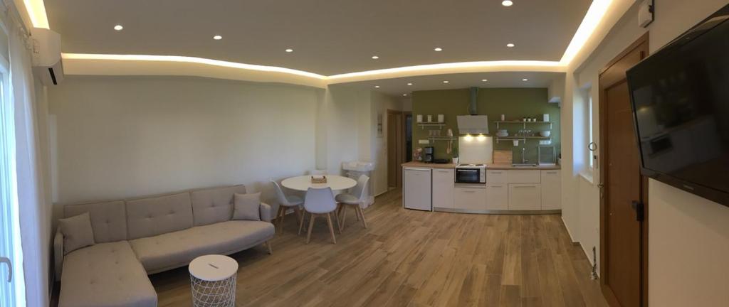 a living room with a couch and a kitchen at Apartment Laoura in Corfu Town