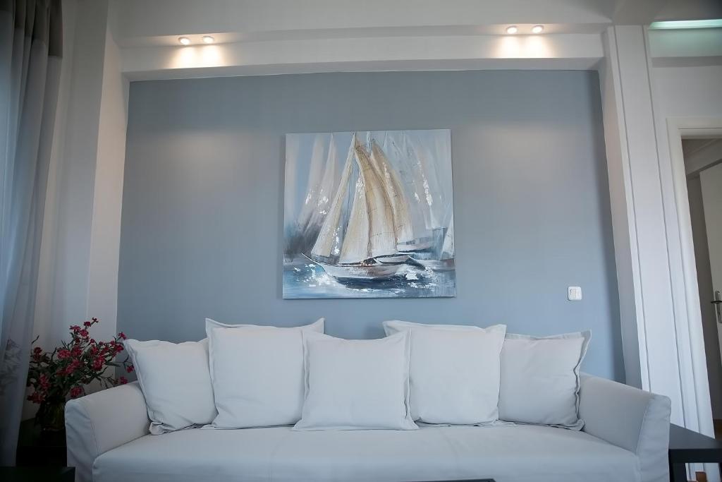 a white couch with a picture of a boat on the wall at Apartment in Glyfada Center in Athens