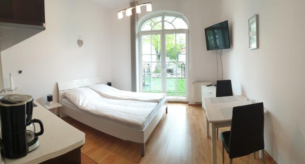 a bedroom with a bed and a table and a window at Apartament Trzy Korony 1 in Świnoujście