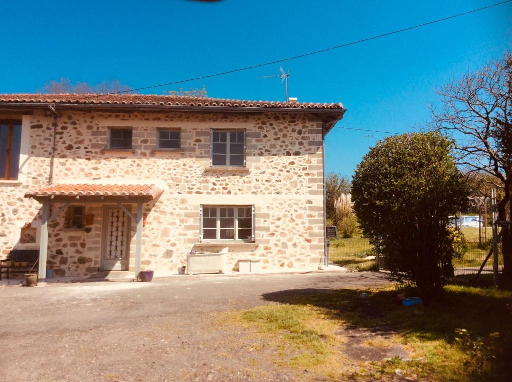 a large stone house with a driveway in front of it at Les Outres in Chabrac