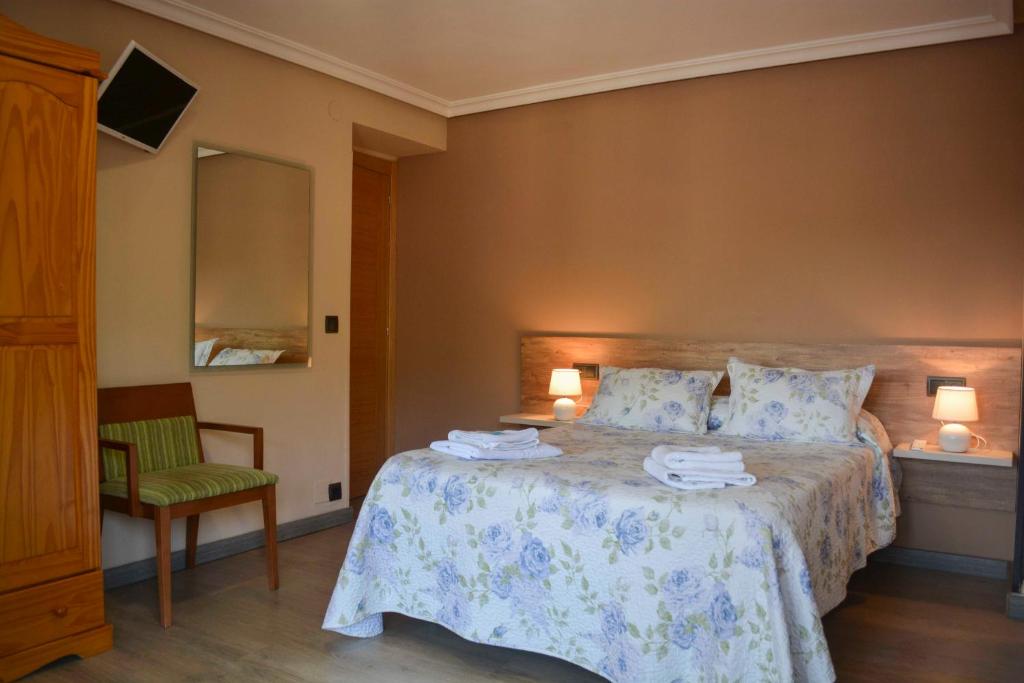 a bedroom with a bed with two towels on it at Pension Reconquista in Cangas de Onís