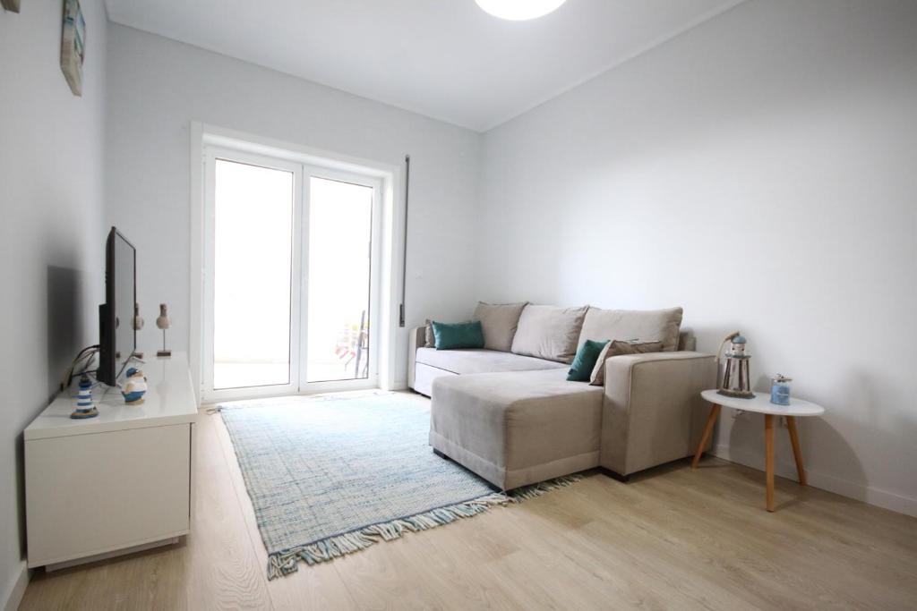 un soggiorno bianco con divano e finestra di Salinas Beach House - T3 Apartment - Costa Nova a Costa Nova