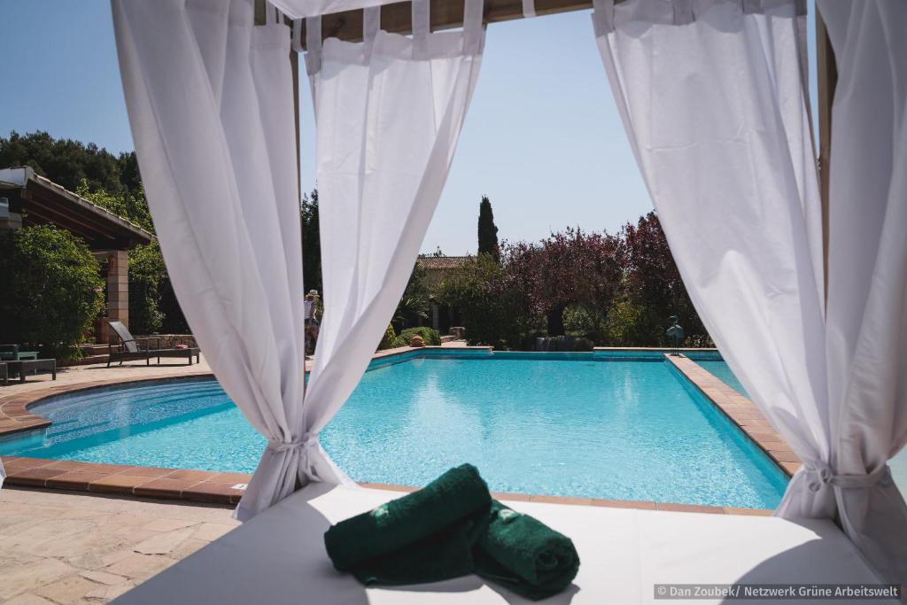 a view of a swimming pool with white curtains at Sa Vaqueria in Porto Cristo