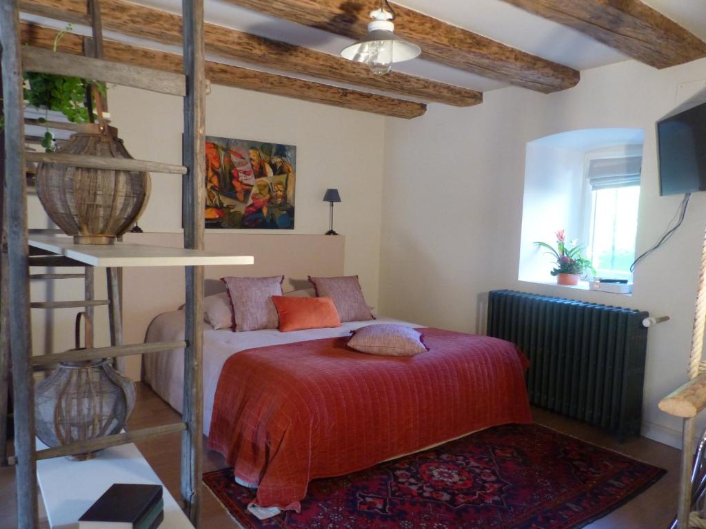 - une chambre avec un lit et une couverture rouge dans l'établissement Le voyage d'UBUNTU, à Heiligenstein