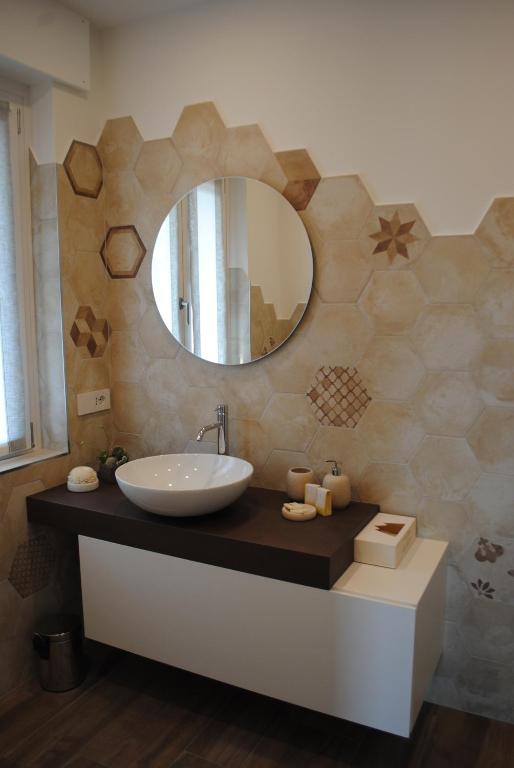 La salle de bains est pourvue d'un lavabo et d'un miroir. dans l'établissement DolceLago, à Sirone