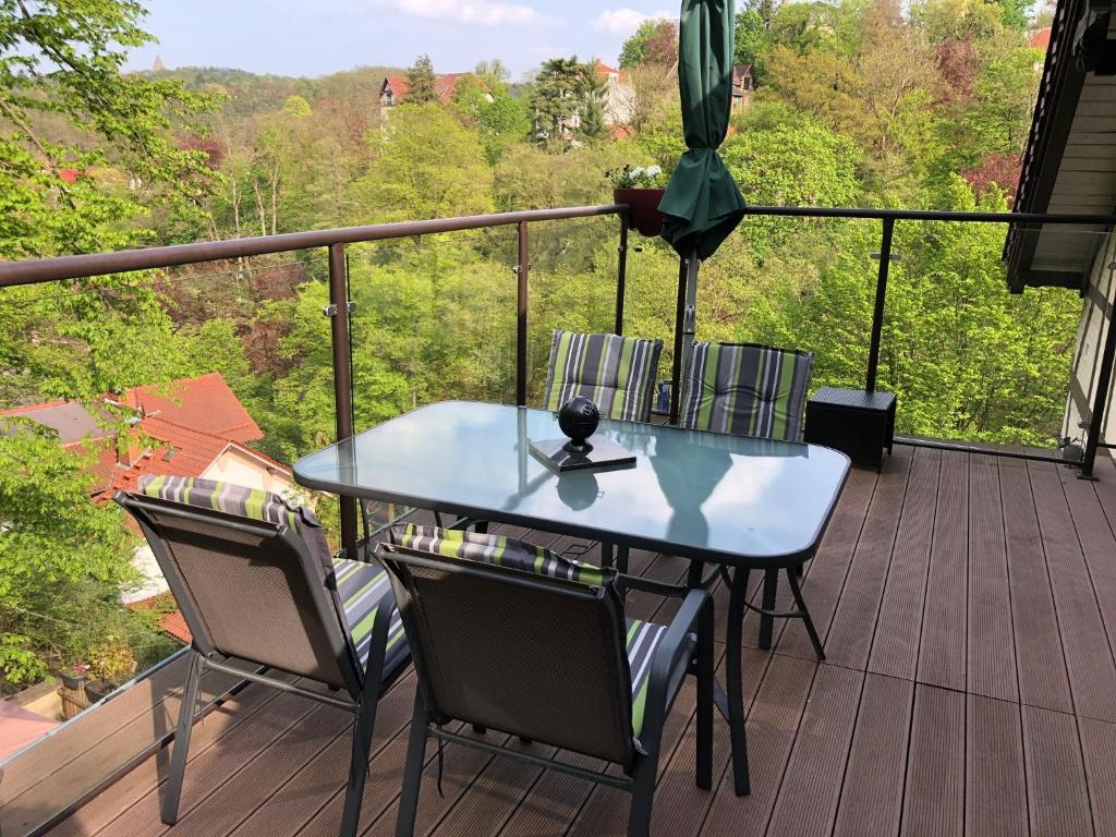 a blue table and chairs on a balcony with a view at Schöne Ferienwohnung DG in Eisenach