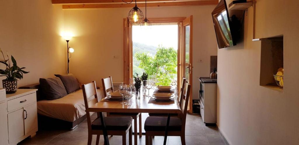a dining room with a table with chairs and a kitchen at Villa Duboka, Otok Vis in Komiža