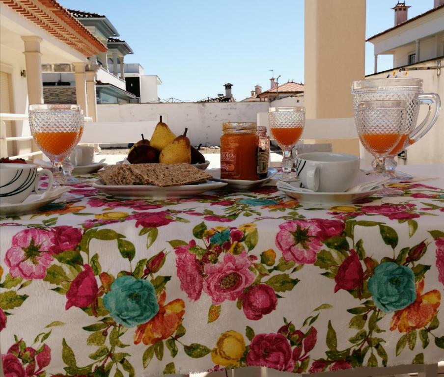 een tafel met een tafelkleed met bloemen erop bij Villa Estrelinha in Nazaré