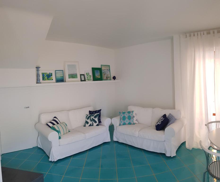 2 divani bianchi posti in soggiorno di Apulia Beach a Leporano