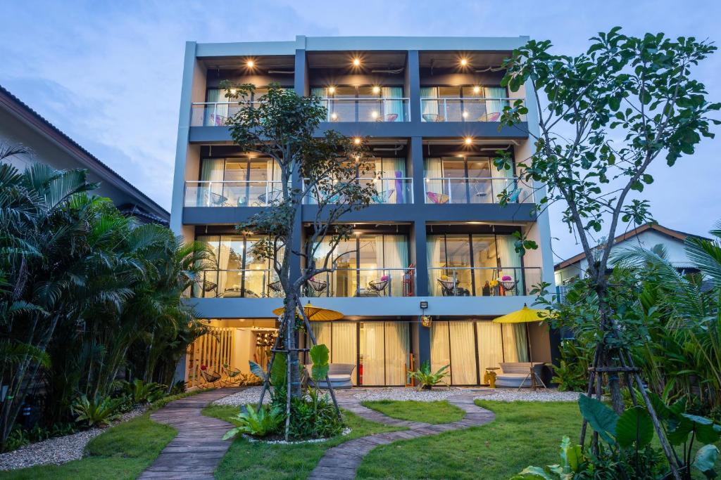 een appartementencomplex met een tuin ervoor bij River Art Hotel in Chiang Mai