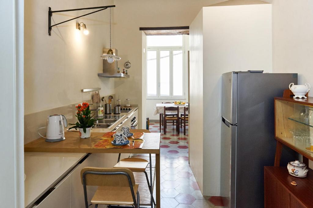 cocina con nevera y mesa con sillas en Casa Conte, en Sorrento