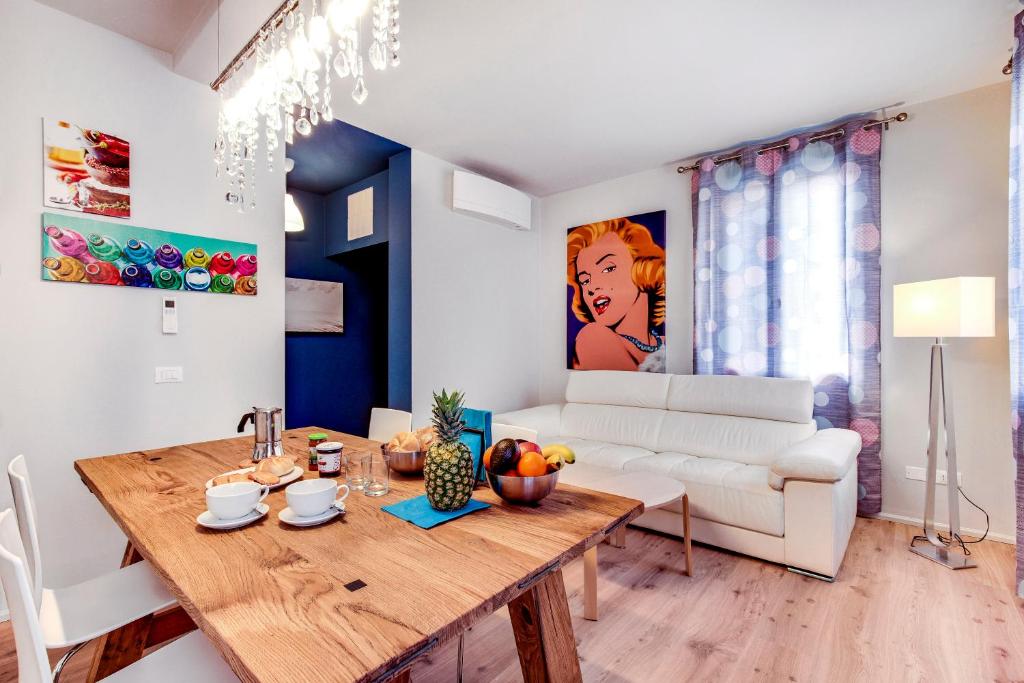 - un salon avec une table et un canapé blanc dans l'établissement Lido's Garden Apartment, sur le Lido de Venise