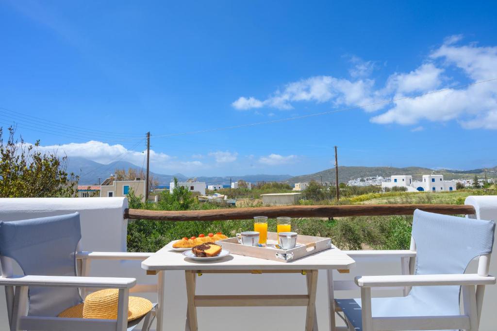 a table and chairs on a balcony with a view at Madalena's Summer House in Adamantas
